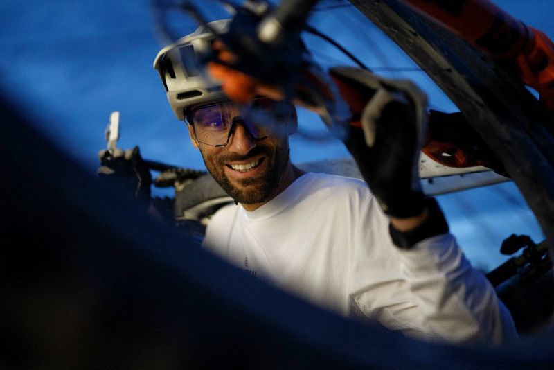  A blue-hour portrait of mountain biker Kilian Bron, shot through the spokes of one of Kilian's bicycle wheels using a Canon EOS R6 Mark III.