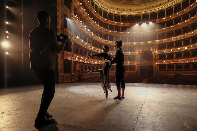 Cinematographer Javier Cortés films two ballet dancers on stage at the Teatro Massimo in Palermo, Sicily.