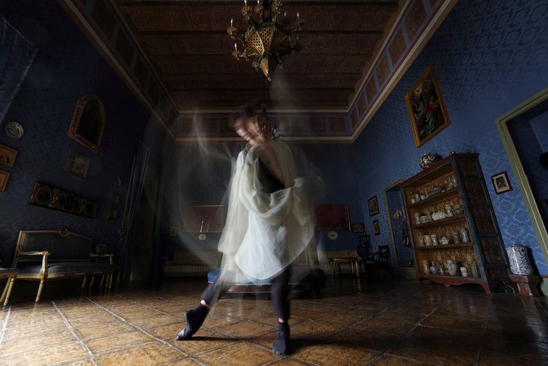 Un balerin schimbând poziţia, braţele fiindu-i neclare din cauza mişcării.