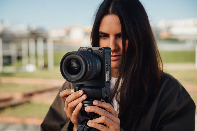 Ustvarjalka vsebin in filmska ustvarjalka Giulia Gartner drži fotoaparat Canon EOS R6 V v navpičnem položaju za snemanje.