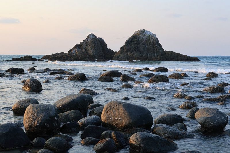 En udsigt over klipper i lavt vand med retning mod et klippefremspring i havet, som er fotograferet med kameraets Auto Level-funktion slået til, hvilket resulterer i en perfekt vandret horisont.