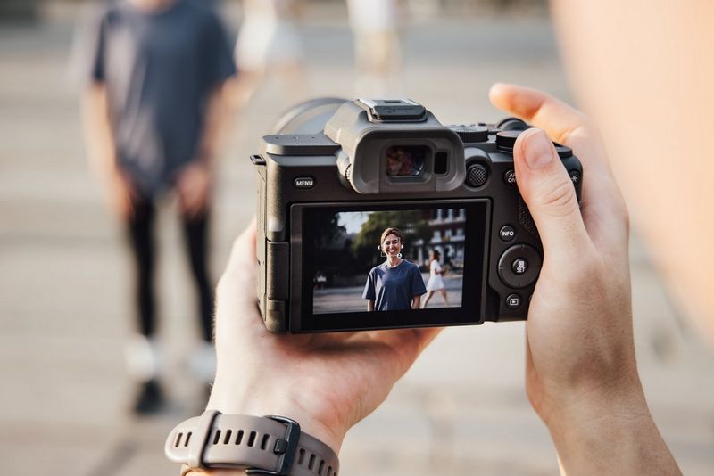 L'écran arrière d'un Canon EOS R8 Mark II tenu par la photographe de voyage Frauke Hameister, montrant le cadre d'autofocus de l'appareil qui sélectionne le visage d'un sujet tandis que d'autres personnes marchent derrière elle.
