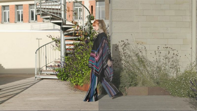 A woman in a colourful poncho, filmed on a Canon EOS R8, with half the image bright and colourful after colour grading and the other half duller.