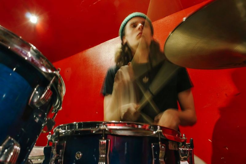 Zámerne rozmazaný záber bubeníka pri bubnovaní.