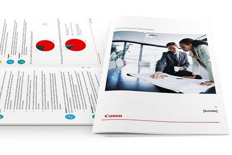 En mand sidder med sin mobiltelefon i hånden samtidig med at han læser om Canons digitale kommunikationsløsninger