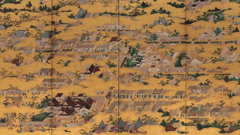 A detailed view of a traditional Japanese folding screen painting depicting a town with gold-leaf clouds.