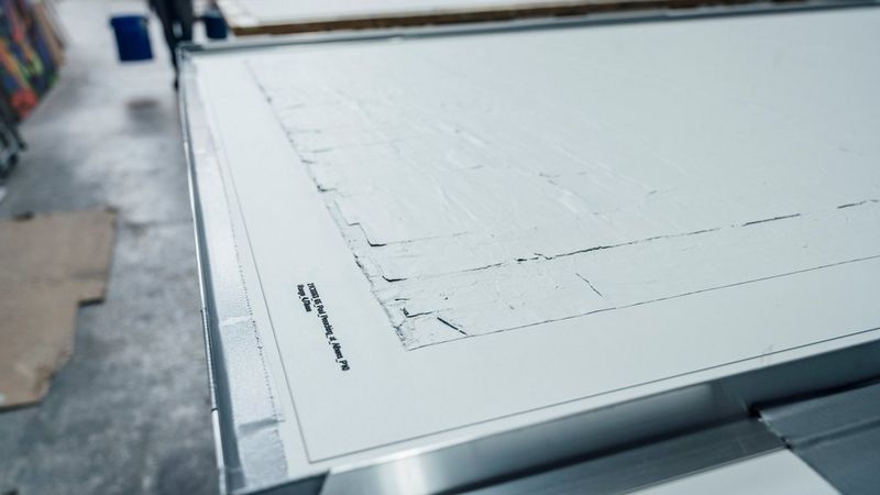 Close-up of a textured white surface in a workshop setting.