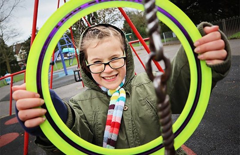 A smiling boy in a playground.