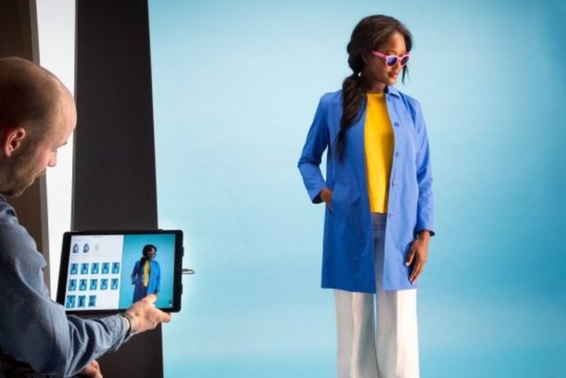 A model in sunglasses and a blue coat being photographed in a StyleShoots photography machine.