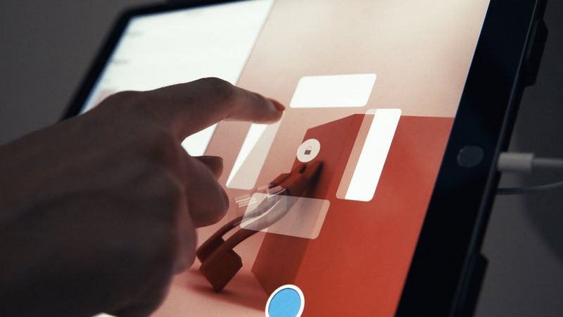 Gros plan d'une personne utilisant une tablette pour contrôler une machine de photographie StyleShoots.