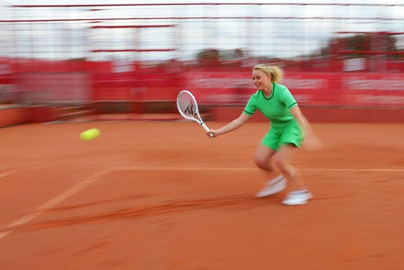 Une joueuse de tennis en plein service, photographiée par panoramique.