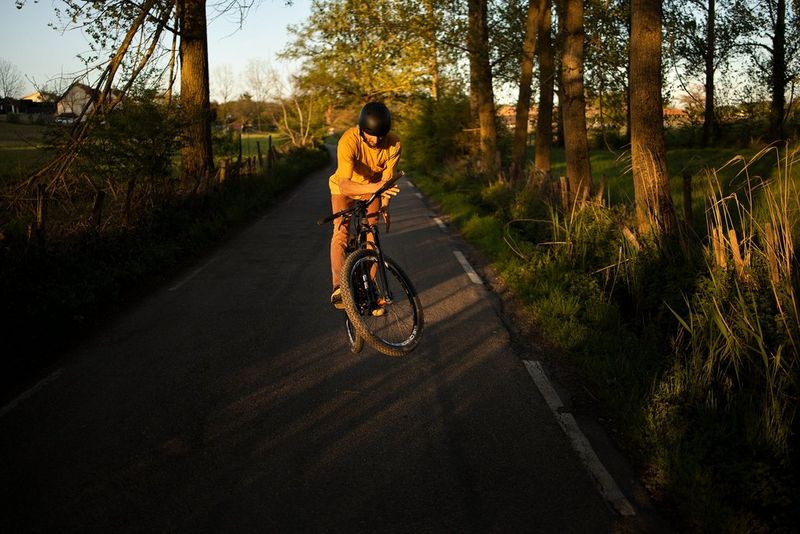 Gorski kolesar, ki skoči med vožnjo po cesti navzdol.