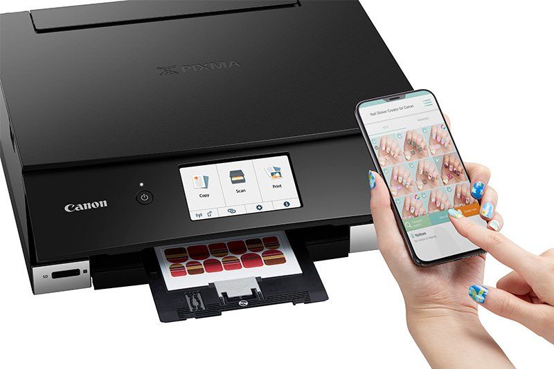 A woman holds a smartphone above a Canon PIXMA TS8340 printer.