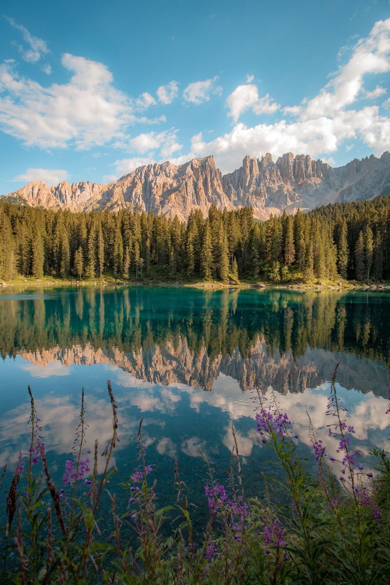 Lago di Carezza in Zuid-Tirol (Italië) op een heldere zomerdag. Met de Dolomieten op de achtergrond,weerspiegeld in het stilstaande water van het meer.