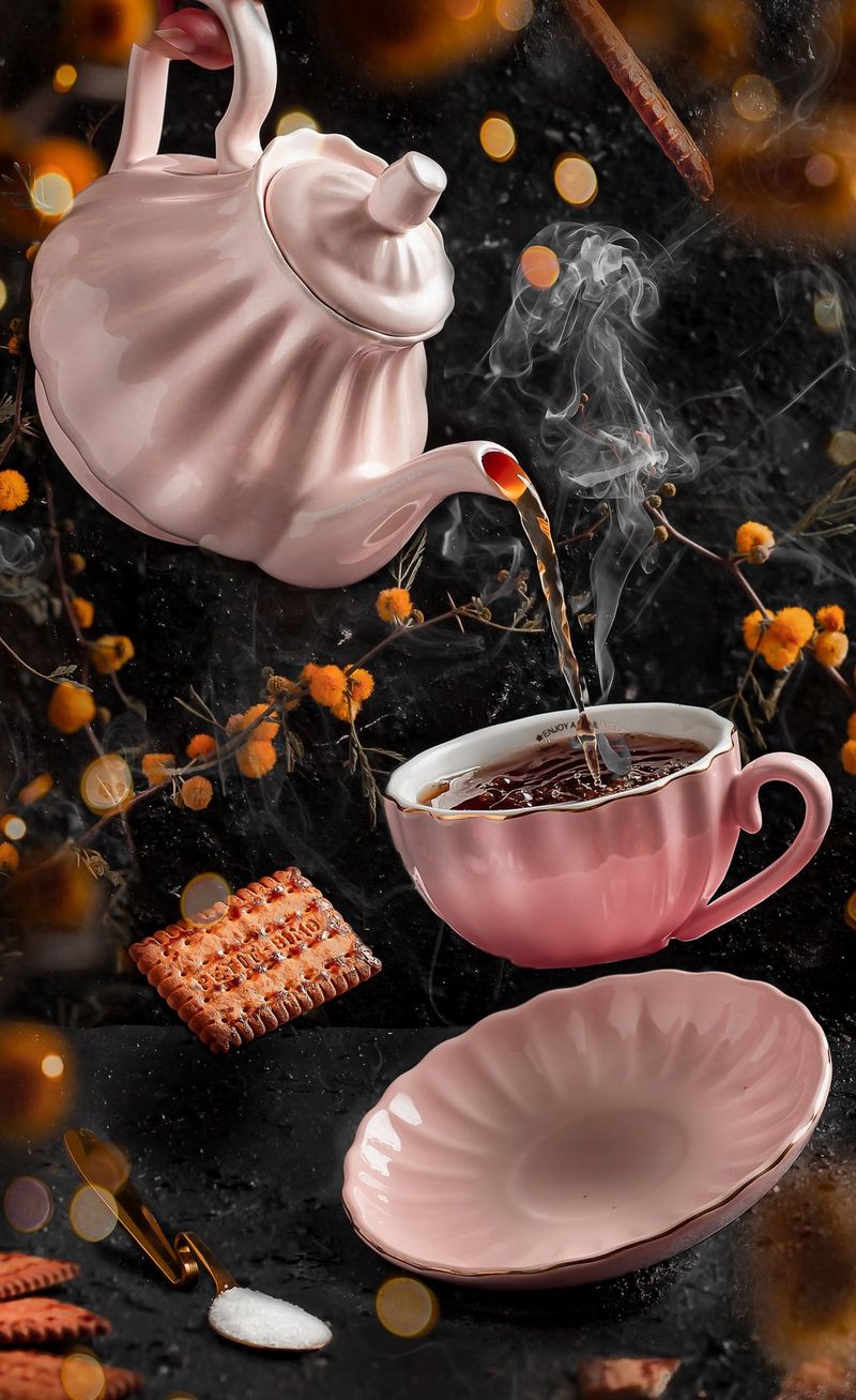 A pink teapot pouring tea into a cup floating in the air above a saucer. 
