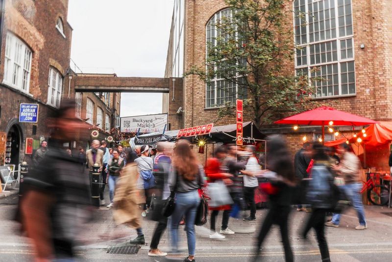 Оживленная улица, по которой во всех направлениях ходят размытые люди.