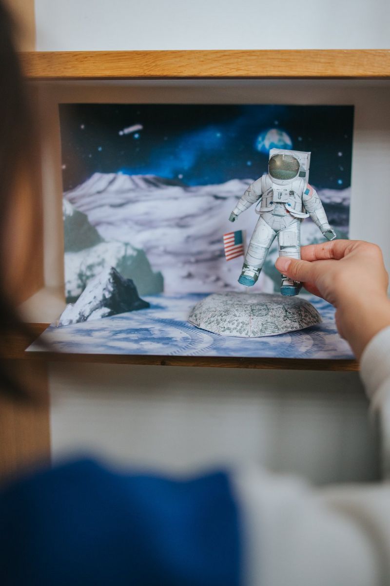 Een kind plaatst een papieren astronaut in een Creative Park Moon-diorama.
