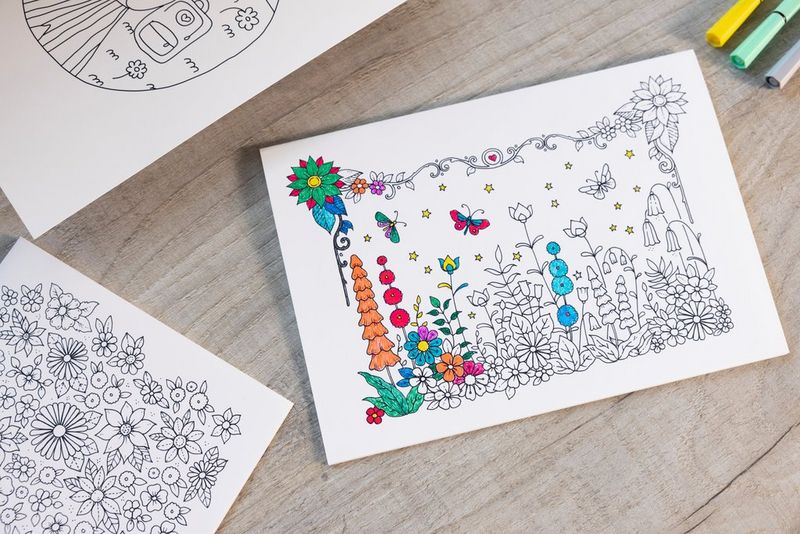 Three colouring pages with different designs, one in the middle half-coloured in with a flower design.