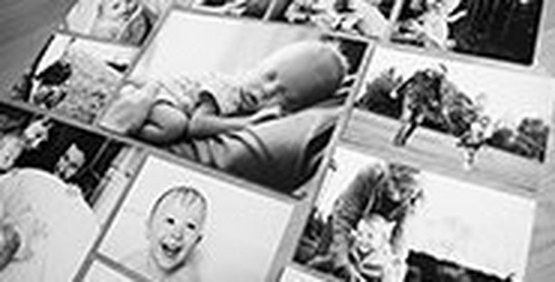 Black and white prints of children and families arranged in a grid style on the floor.