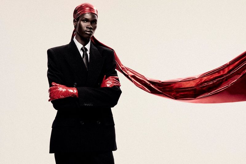Na modnoj fotografiji Iana Hippolytea snimljenoj fotoaparatom i objektivom tvrtke Canon, model stoji prekriženih ruku, nosi dizajnersko odijelo, crvene lateks rukavice i dugi crveni durag koji se proteže s jedne strane slike.