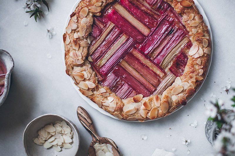 A rhubarb topped cake, with flaked almonds round the edge. 