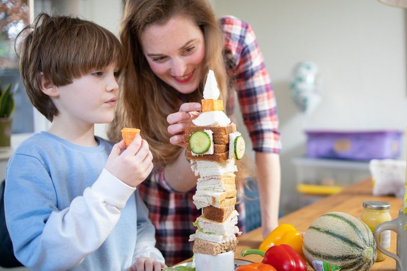 Een moeder en zoon maken een toren van eten die lijkt op de Big Ben-klokkentoren in Londen.
