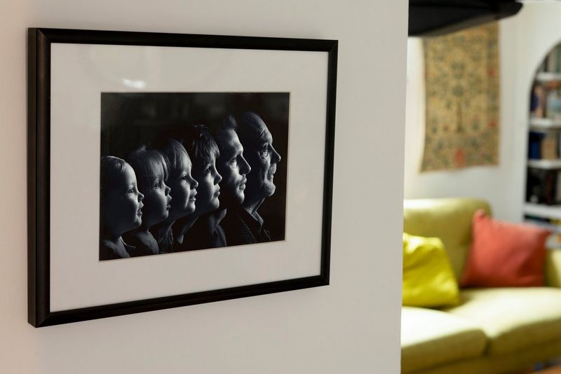 Črno-bel družinski portret obrazov v profilu, uokvirjen in obešen na steno.