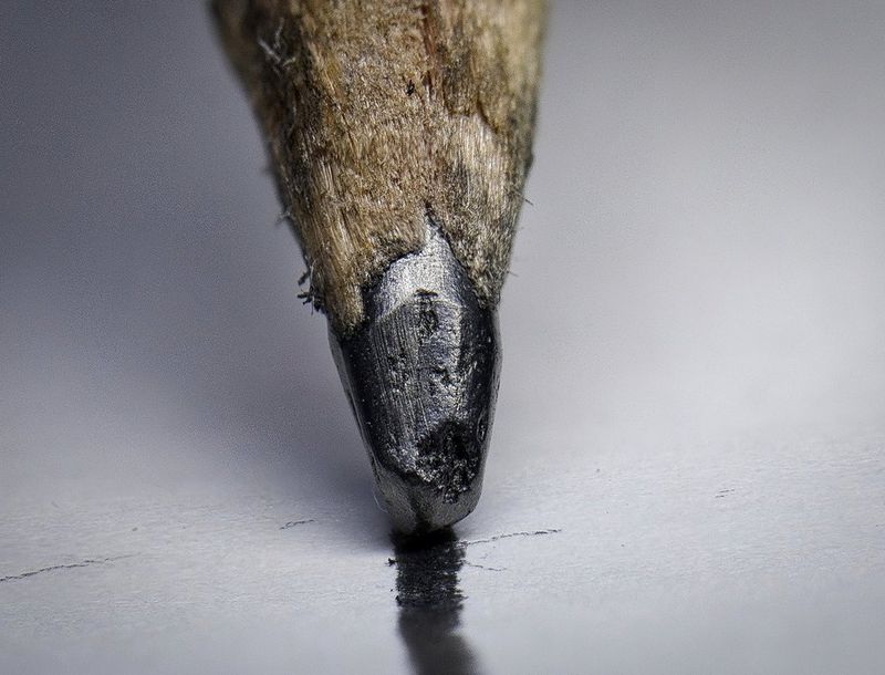 Fotografia macro di una matita che disegna una linea su un foglio.
