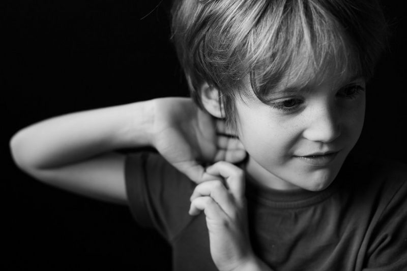 Сбоку на мальчика падает мягкий рассеянный свет.