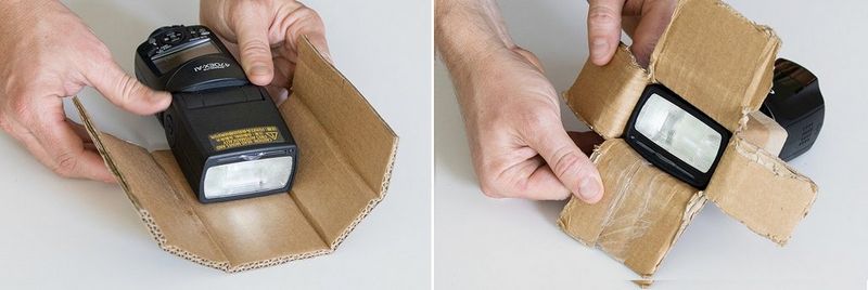 Two hands bend a piece of cardboard around the sides of a Canon Speedlite flash.