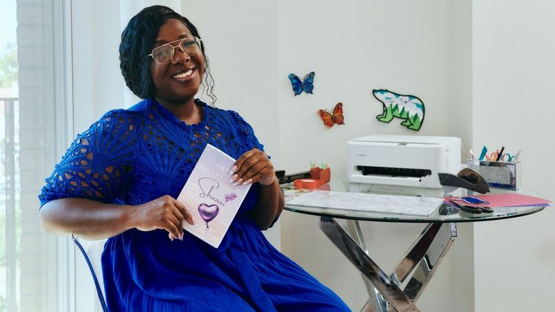 Juliet Amma tiene in mano un biglietto di compleanno fatto a mano, stampato con una stampante Canon PIXMA sulla piccola scrivania dietro di lei. © Marc Sethi