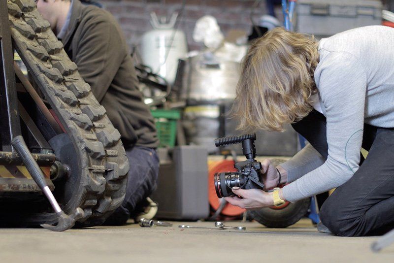 Geoff crouching on the floor taking a video of the robot with EOS 80D.