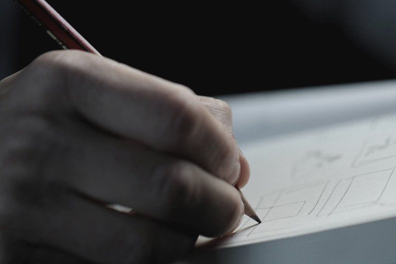 Geoff drawing storyboard with pencil in a notebook.