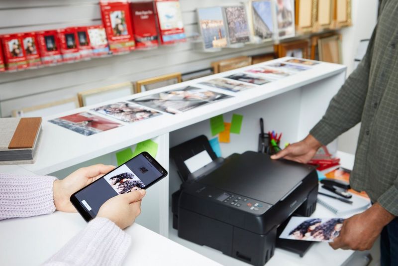 Een printer uit de PIXMA G-serie die een foto vanaf een smartphone print.