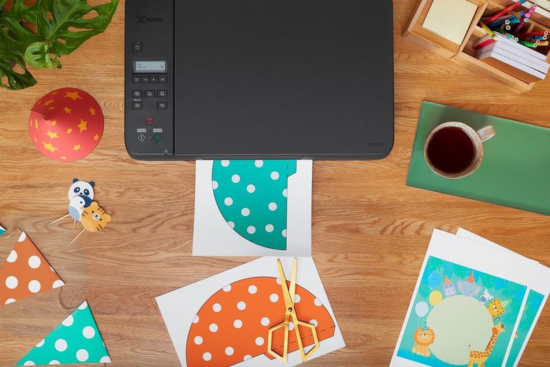 Een bovenaanzicht van de Canon PIXMA G3520-printer met knutselpapier op het bureaublad.