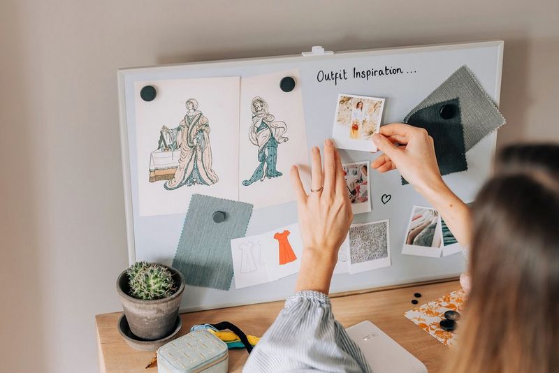 Žena izrađuje ploču sa slikama s idejama za odjevne kombinacije, pričvršćujući slike ispisane pisačem SELPHY Square QX10 pokraj crteža i uzoraka tkanina.