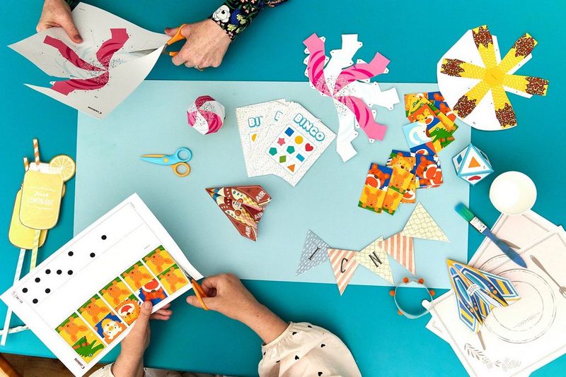 Shora vyfotografované šablony služby Creative Park a částečně složené papírové modely rozložené na stole.