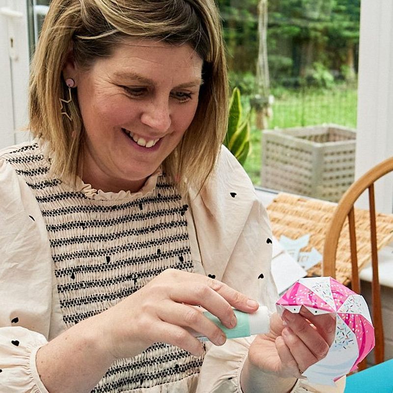 La creatrice Emma Howcutt-Kelly sorride mentre incolla un gelato di carta stampato da Canon Creative Park.