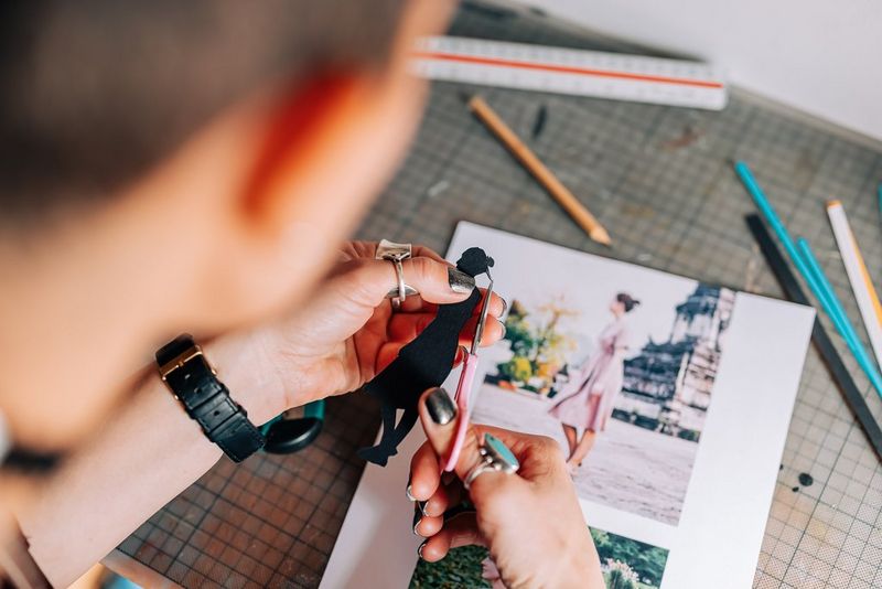 Una persona ritaglia con cura la sagoma di una donna.