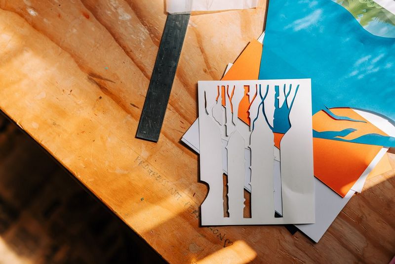 Un pezzo di carta bianco su un piano con betulle bianche ritagliate.