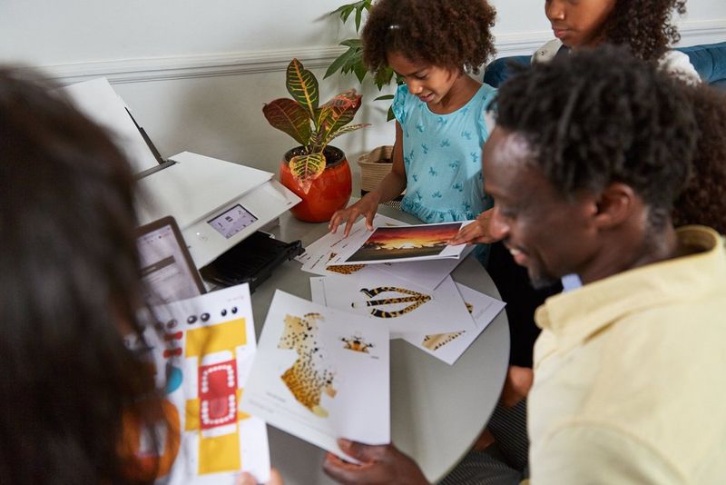 Члены семьи передают друг другу бумажные модели, напечатанные на листах формата А4.