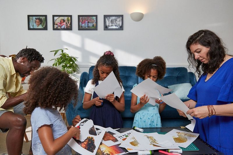 Вся семья собралась в гостиной вырезать бумажные шаблоны.