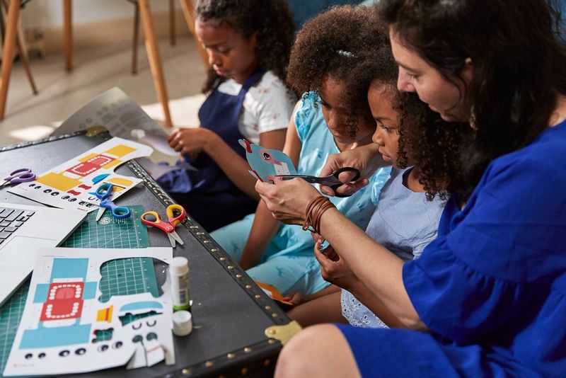 Семья вырезает фигурки животных из бумаги.