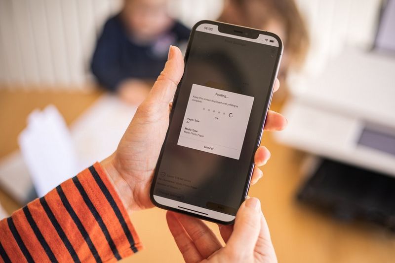 Een persoon die op een telefoon de Creative Park-app gebruikt om te printen.