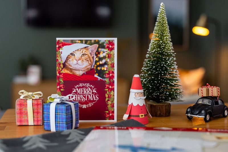 Een thuis geprinte kerskaart uitgestald samen met geknutselde decoraties en een kerstboomversiering.