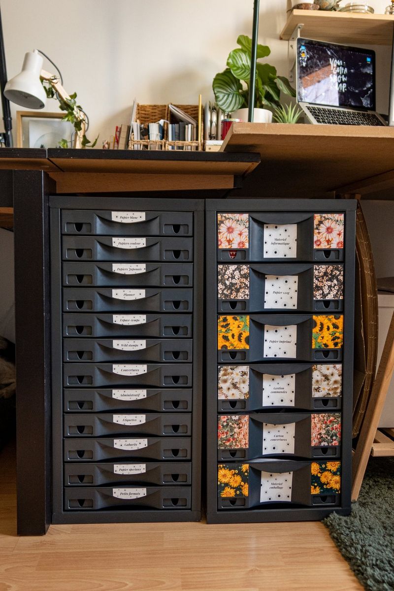 Black storage drawers in an office setting organised with colourful, homemade printed labels.