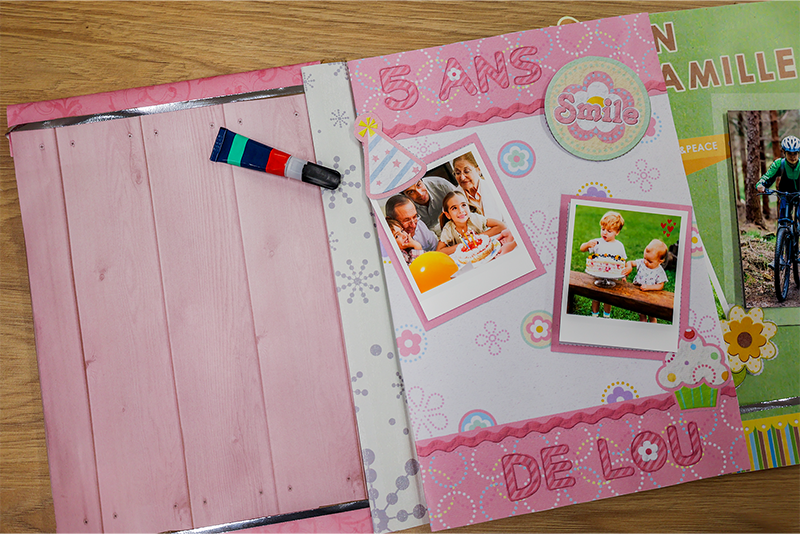 Розовые страницы альбома и тюбик с клеем поверх них.