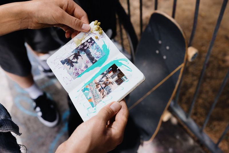 Dve stránky albumu s výstrižkami skejtbordistky Heleny Longovej s fotografickými výtlačkami vyrobenými pomocou prenosnej tlačiarne Canon Zoemini 2 spolu s ručne nakreslenými grafickými prvkami a malou vetvičkou kvetov v jednom rohu.