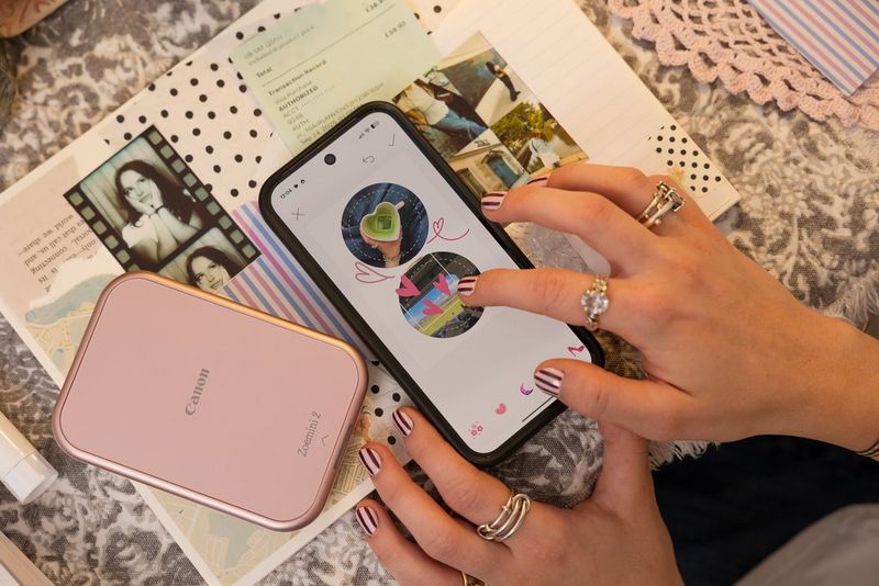 Bir kullanıcı, yanında duran bir Canon Zoemini 2 yazıcıda basmak üzere akıllı telefonundaki Canon Mini Print uygulamasında yuvarlak bir çıkartma görüntüsünü özelleştiriyor.