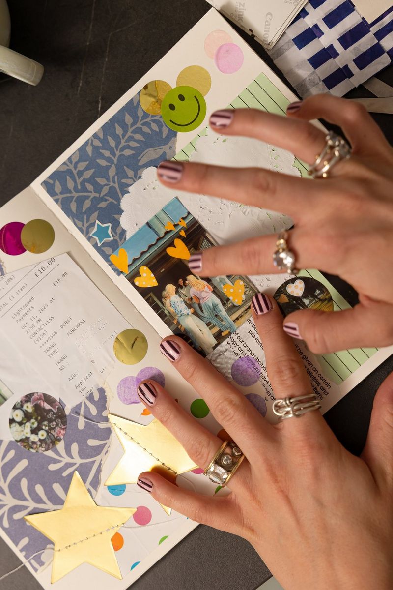 İki el, Canon Zoemini 2 yazıcıyla basılmış bir fotoğrafı, çeşitli şekiller, nesneler ve renkli desenlerle dolu bir karma günlük sayfasına yapıştırıyor.